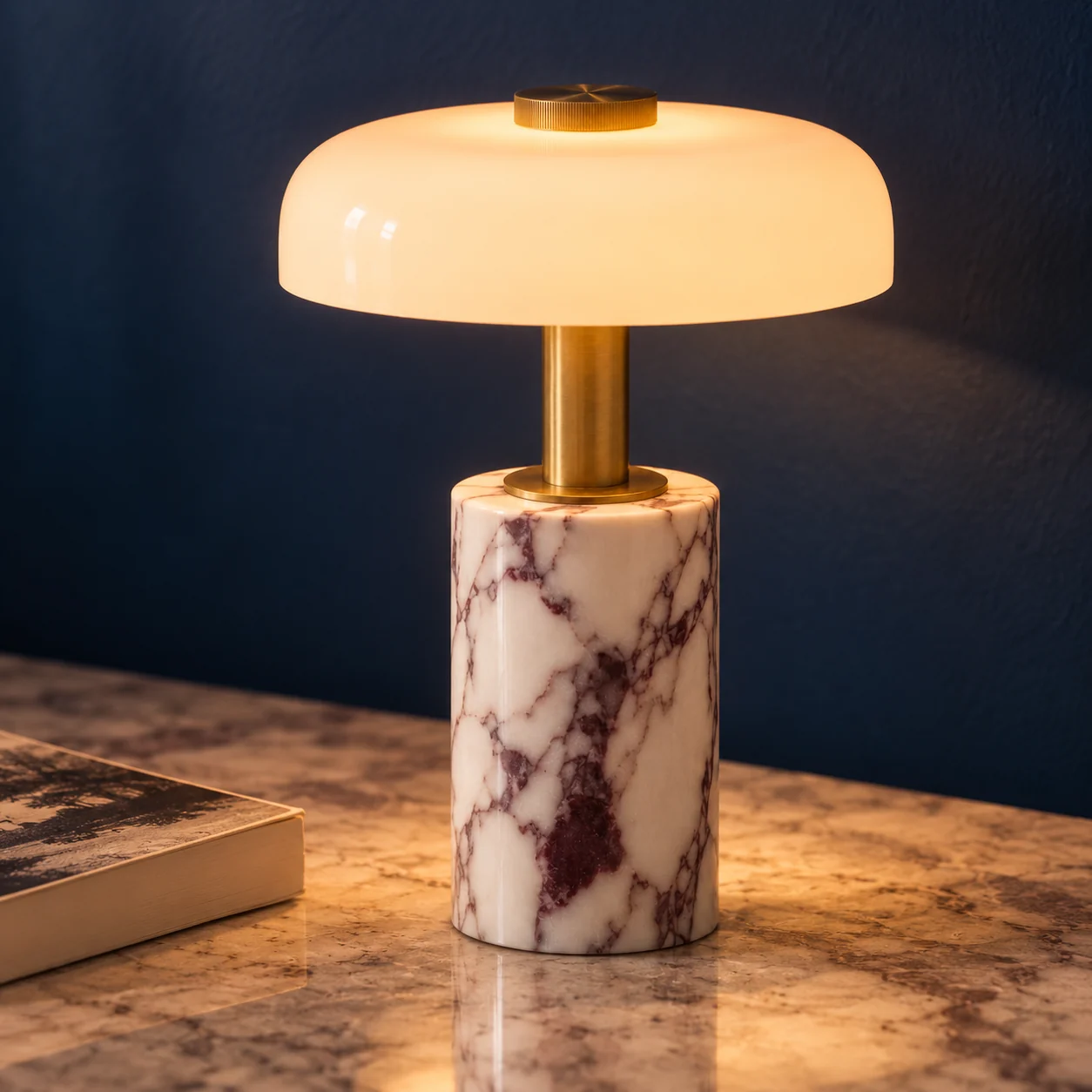 Cordless lamp with a glowing glass dome, brass stem and white veined marble base.