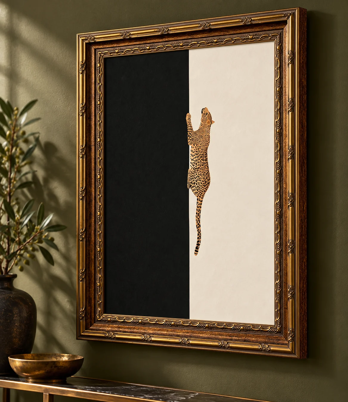 Gold-framed leopard print with a split black and cream background on an olive wall.