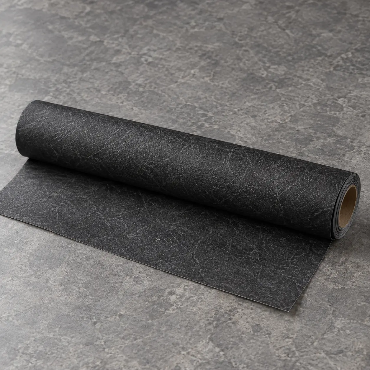 Roll of black textured peel-and-stick wallpaper partially unrolled on a gray stone surface